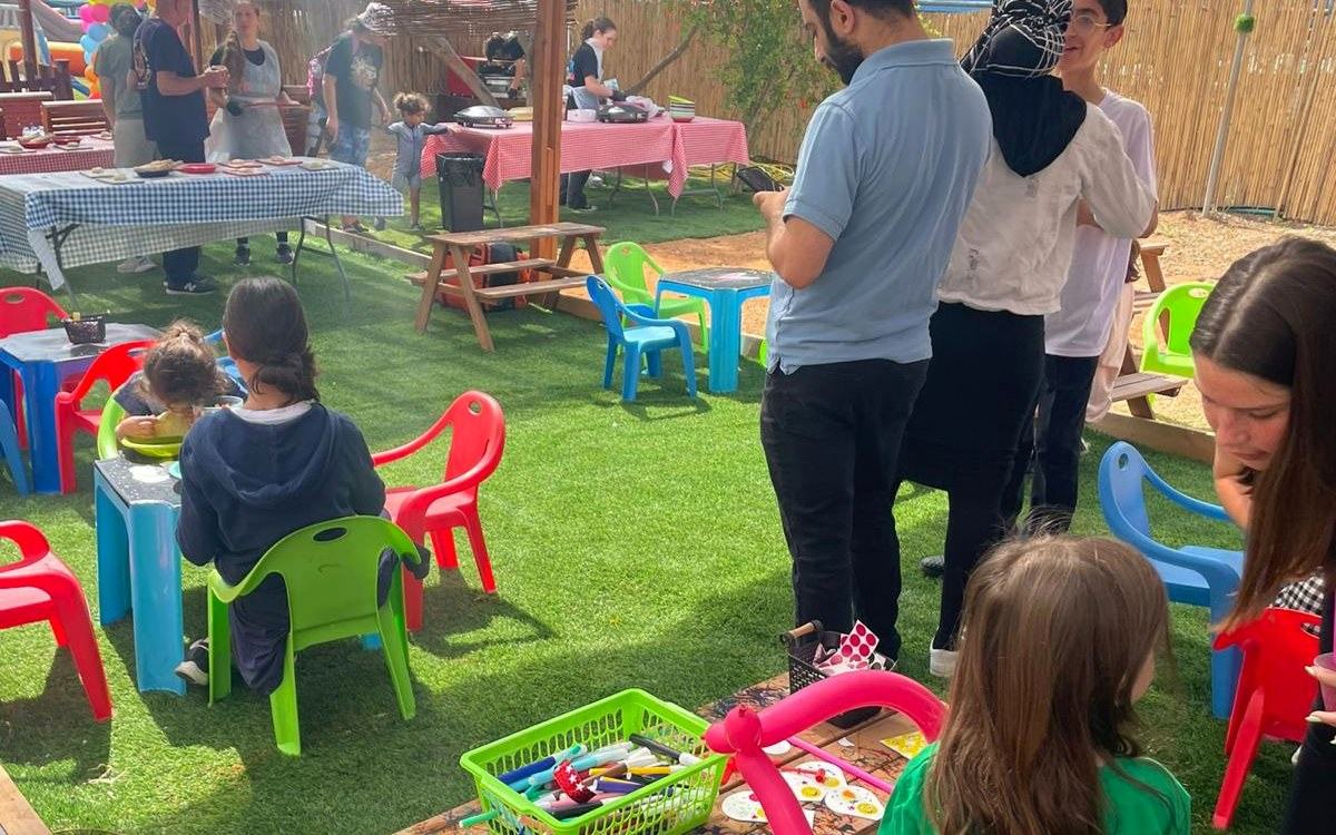 צוות עם ילדים סביב שולחנות יצירה